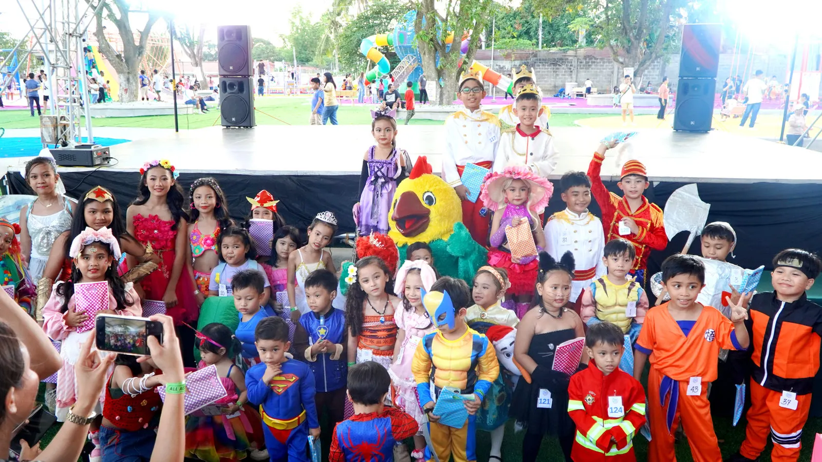 Group of kids in costumes posing with the Fiesta mascot